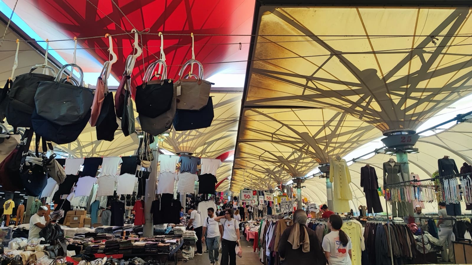 Kadıköy Tarihi Salı Pazarı'nın tekstil sıraları — kırmızı-beyaz tente örtüsünün altında çanta ve giyim tezgâhları
